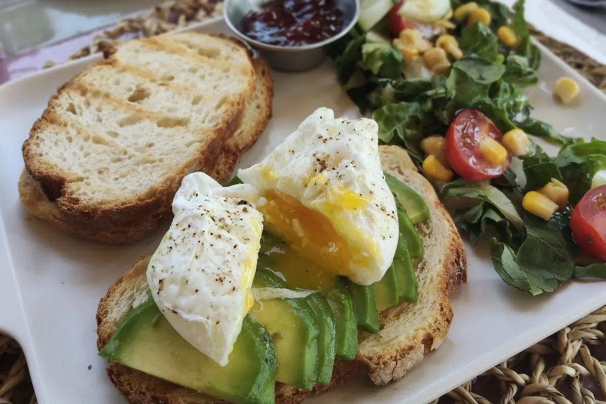 Toast avocat et œuf poché coulant du petit-déjeuner Le Petit Paris à La Secret Beach Marrakech — La Secret Beach, beach club 100 % femmes à Marrakech